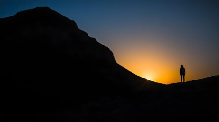 Silhouetted figure standing in the shadows as a majestic mountain landscape fades into the twilight of an atmospheric sunset evoking a sense of farewell and contemplation