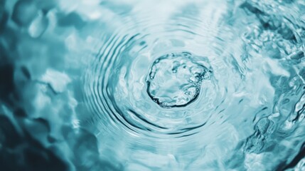 A macro photograph of a water drop impacting a calm surface, creating ripples. The intricate details of the splash and the serene water surface depict simplicity and tranquility.
