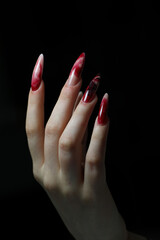 Closeup of elegant female hand with red stiletto nails . Long red nails
