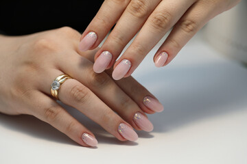 Beautiful nude manicure. Manicure with gel polish. Close-up of the hands of a young woman with a delicate nude 