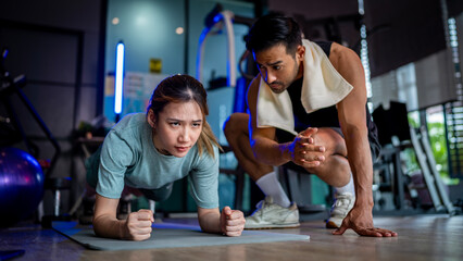 Asian man and woman working out, one is a trainer, the other is an exerciser.