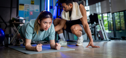 Asian man and woman working out, one is a trainer, the other is an exerciser.