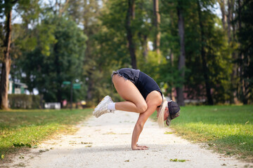 Sports blonde yoga practitioner, performs Bakasana exercise, crane pose, handstand, practices in...