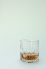 Soft, diffused lighting creates gentle reflections and subtle shadows on the glass and liquid.