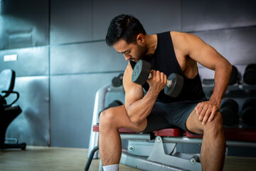 Fototapeta premium A strong Asian man is exercising to build muscle.