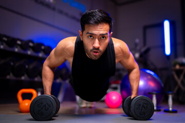 A strong Asian man is exercising to build muscle.