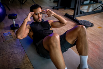 Naklejka premium A strong Asian man is exercising to build muscle.