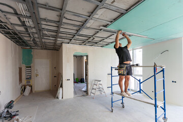 Drywall Installers. Men holding a gypsum board figured cut