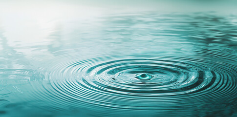 Fototapeta premium Circular ripples spread across the water surface from a teal object, creating an entrancing and calming visual effect, reflecting themes of impact and tranquility in nature.