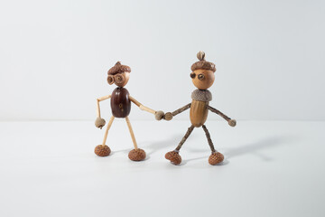 Couple of acorn figurines standing together, showcasing folk art creativity. Handmade nature inspired sculptures, perfect for rustic decor, eco-friendly crafts, and autumn-themed projects