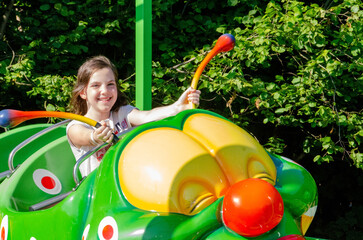 Happy daughter riding the merry-go-round. With the speed of going on a roller coaster, laughing,...
