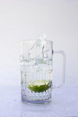 Water Splash Photography. A sliced lime throw down in the glass of water. It creates a beautiful water splash in motion.