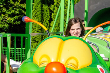 Happy daughter riding the merry-go-round. With the speed of going on a roller coaster, laughing,...
