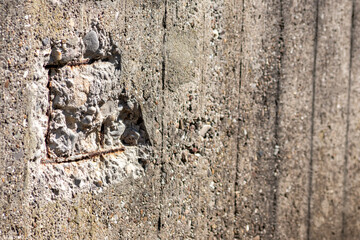 Broken concrete wall with details of ferroconcrete structure as reinforced concrete with metal skeleton shows damages and ailing and aging concrete wall or bunker protection in war time after attacks