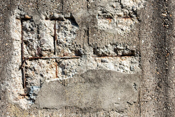 Broken concrete wall with details of ferroconcrete structure as reinforced concrete with metal skeleton shows damages and ailing and aging concrete wall or bunker protection in war time after attacks