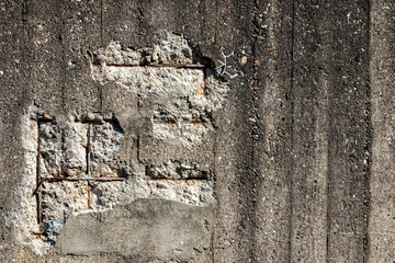 Broken concrete wall with details of ferroconcrete structure as reinforced concrete with metal skeleton shows damages and ailing and aging concrete wall or bunker protection in war time after attacks