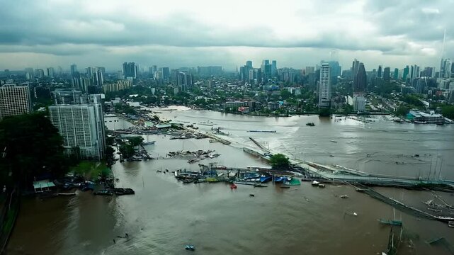 Drone footage of a flooded river caused a damage in a city under cloudy sky