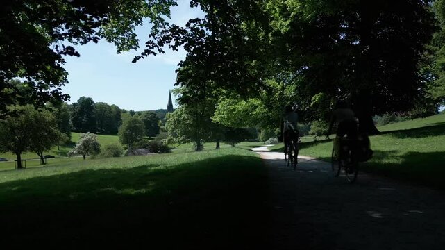 Bikers riding in a green park in the English village of Edensor at the daytime in Derbyshire UK