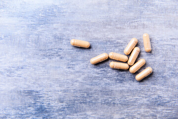 Lutein capsules. Dietary supplement on wooden background. Soft focus. Top view. Close up. Copy space.	