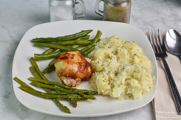 barbecue chicken thigh with asparagus and green  beans.