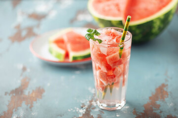 Summer infused water. Glass of tasty cold watermelon lemonade on the table