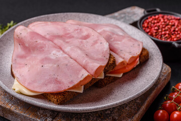 Sandwich with toast, ham, cheese, tomatoes, salt, spices and herbs