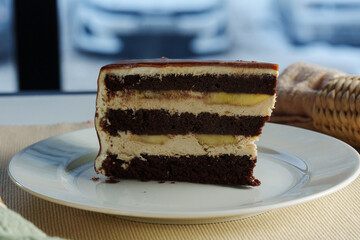 Decadent chocolate layer cake with creamy frosting showcased on a pristine plate against a dark backdrop