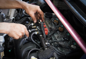 Hands man auto mechanic tuner LPG system of car engine on car engine background for maintenance or repair service concept.Close up.