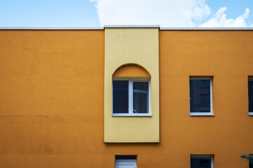 Several windows on the wall of a building with a yellow facade