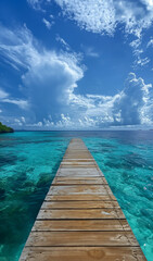 Fototapeta premium A wooden jetty walkway in the maldives a wooden bridge to tropical huts over the Indian ocean - a tropical paradise, luxury resorts horizon