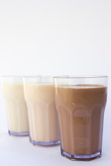 Morning Beverage Options”: Picture these glasses of milk on a white table. Each flavor caters to different preferences: the health-conscious, the traditionalist, and the chocolate aficionado.