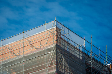 Scaffold sheeting net wrapped apartments building during insulation in england uk
