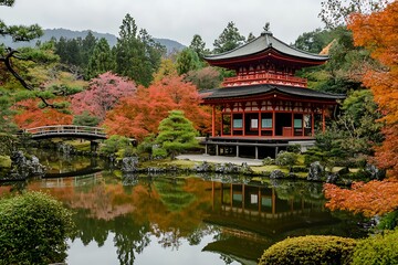 Naklejka premium Traditional Japanese temple with red roof in autumn garden with pond and bridge