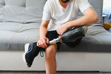 Man amputee with prosthetic leg disability on above knee transfemoral leg prosthesis wearing shoe...