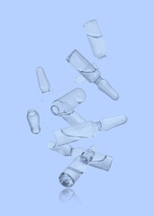 Many ampoules and glass pieces falling on light blue background