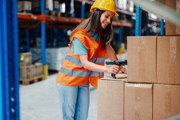 Young woman scanning boxes in a warehouse with a joyful smile.