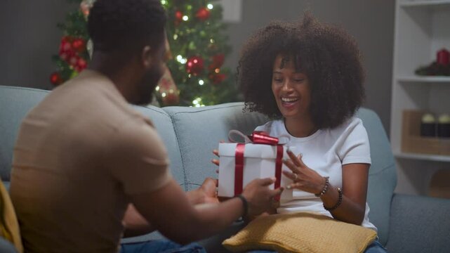 African american boyfriend surprising girlfriend with christmas gift