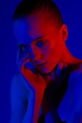 Fashion portrait of beautiful young woman in blue red neon light