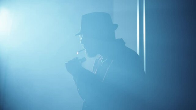 Noir spy film character smoking a cigarette in a dark room. High quality 4k footage