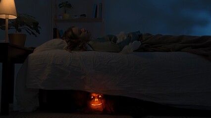 Woman sleeping in bed in dark apartment room, monster with scary face hiding under bed, creepy hand crawling out and touching girl. Halloween horror concept. © kinomaster