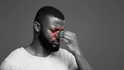 Tired afro man touching his nose bridge, suffering from eye pain, tired eyes, copy space