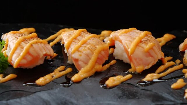 Hand using red chopsticks picking up salmon sush