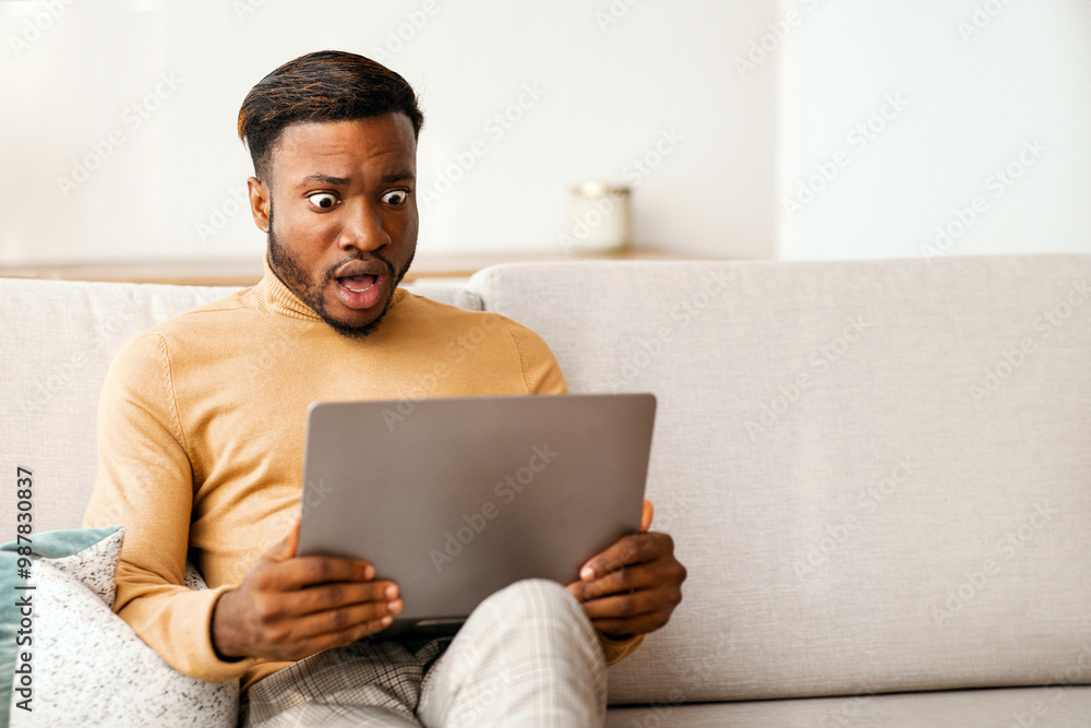 Canvas Prints Shocked Black Guy Looking At Laptop Computer Working Sitting On Couch At Home. Selective Focus