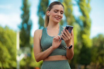 Portrait of sporty woman holding her phone