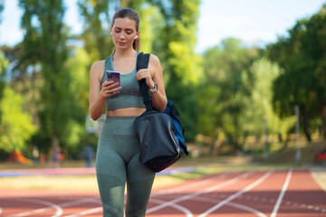 Portrait of sporty woman holding her phone