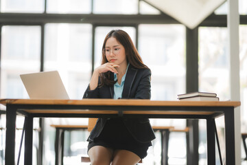 Asian businesswoman working on digital laptop computer at table office. Technology and digital marketing online concept.