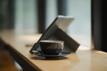 Coffee Break Productivity: A steaming cup of coffee sits by a tablet, embodying the balance of work and relaxation in a modern workspace.  