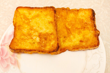 Golden brown french toast on a flower plate
