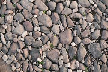 Top view of stone road fragment. Dry land with stones. Abstract natural textured background.
