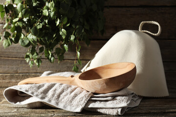 Sauna equipment. Felt wool hat, ladle and towel on wooden surface